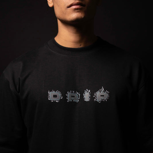 Person wearing a black sweatshirt with 'Drip' text design on a dark background